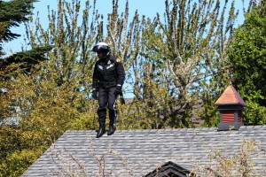 A WSP Motorcycle Cop searches a roof for the gun.