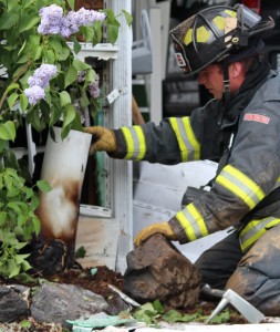 A firefighter examines a burned pipe