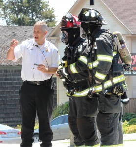 Battalion Chief Matt Keller talks to two firefighters who took photos of the tubes